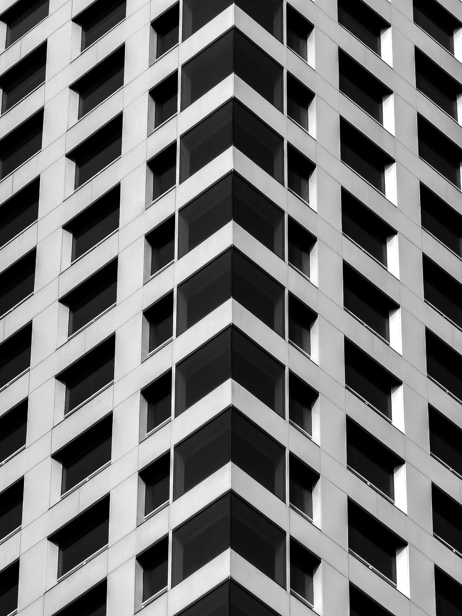 Fachada de edificio corporativo en blanco y negro, ángulo arquitectónico