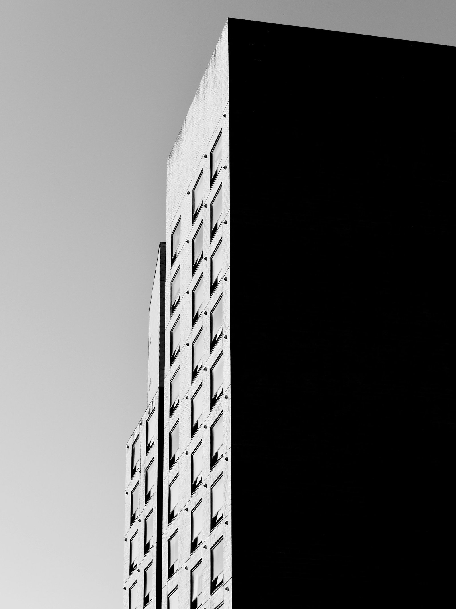 Fachada de edificio con patrón de ventanas geométrico en blanco y negro